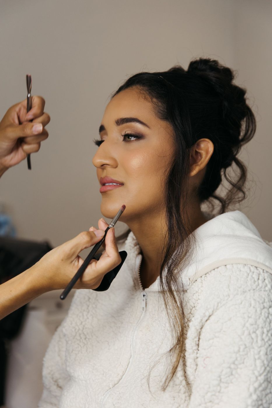 Soft glam bridal makeup with glowing skin and a rosy lip, in profile