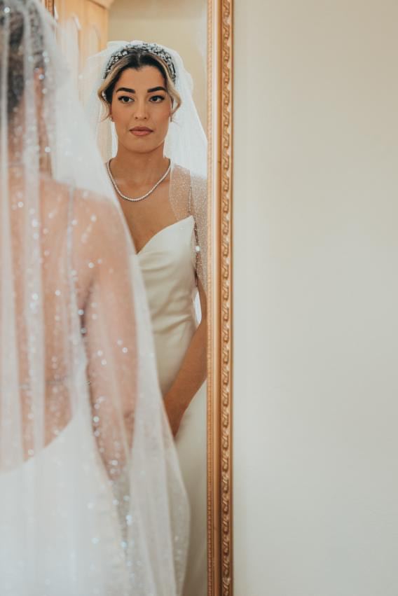 Bride with a crystal tiara reflected in a gold mirror